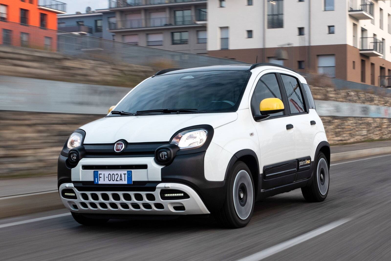 Fotografia in movimento della Nuova Fiat Pandina 2024 di colore bianco con gli specchietti gialli, mentre è in marcia in una strada urbana.