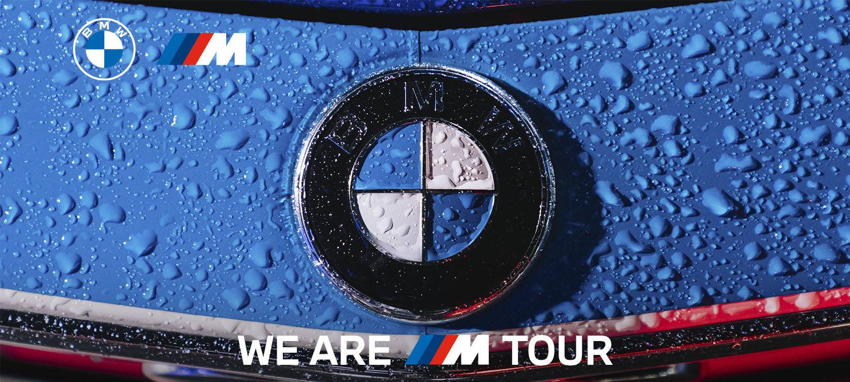 Copertina della news sul We Are M Tour BMW, con il logo BMW in primo piano su una superficie blu con gocce d'acqua e il logo della serie M accanto. Evento esclusivo di test drive per i modelli iconici della serie M presso Gruppo Brandini.