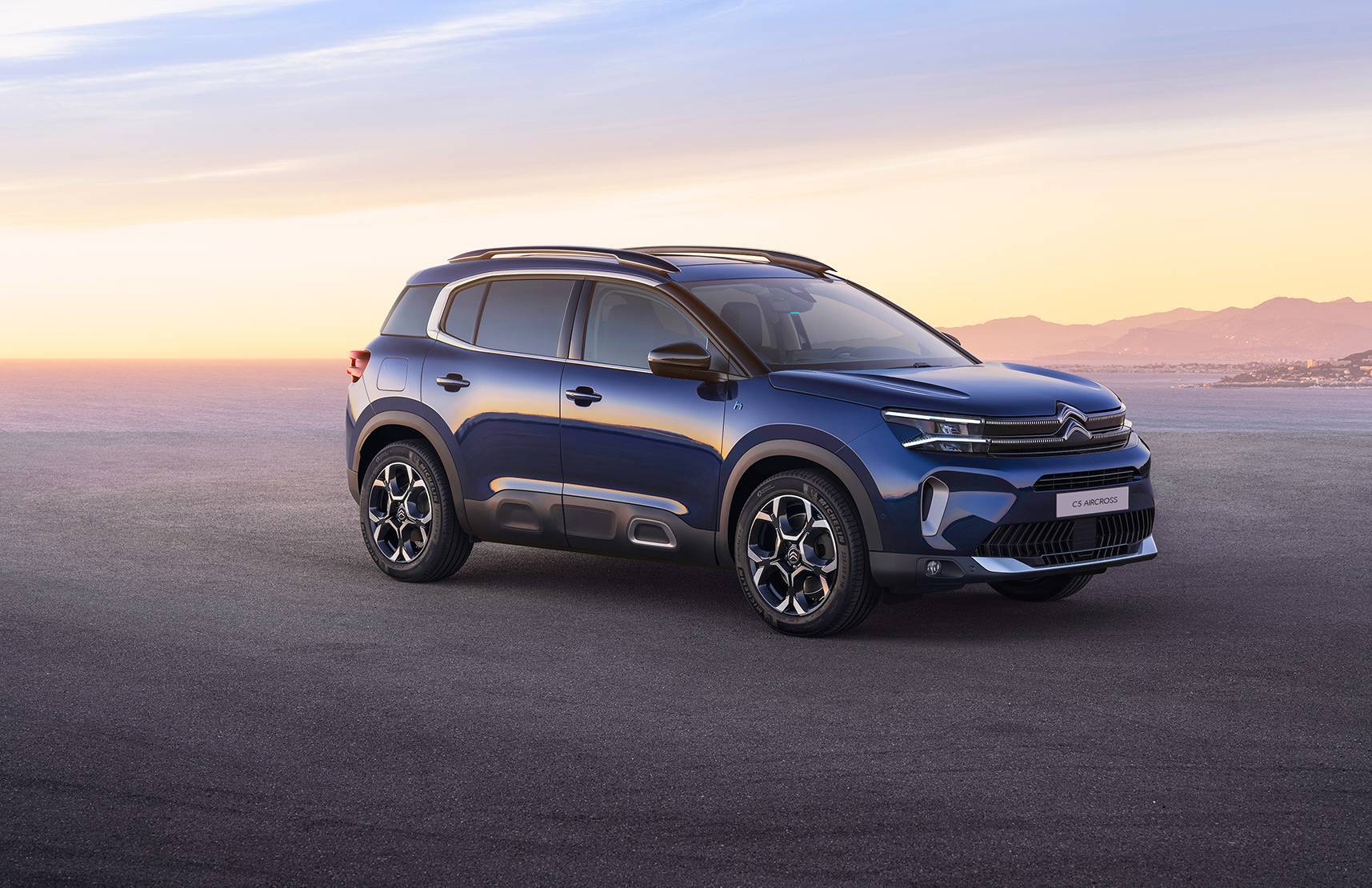 SUV Citroën C5 Aircross blu parcheggiato su una strada panoramica al tramonto, evidenziando il design elegante e i cerchi in lega da 17 pollici. Disponibile presso le concessionarie Brandini, incluse le sedi di Firenze Nord, Firenze Sud, Borgo San Lorenzo