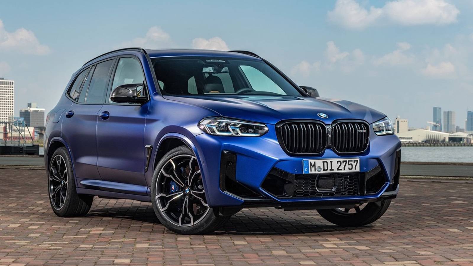 BMW X3 M Competition blu metallizzato in primo piano, un SUV elegante e sportivo parcheggiato su un viale urbano, simbolo dell'innovazione Neue Klasse disponibile presso Brandini BMW Firenze e Pistoia