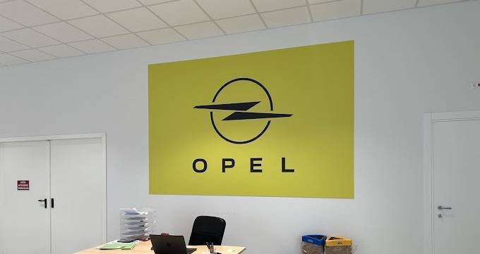 Foto dell'interno della concessionaria Opel del Gruppo Brandini nella sede di Lucca, nella foto possiamo vedere il marchio Opel su sfondo giallo.