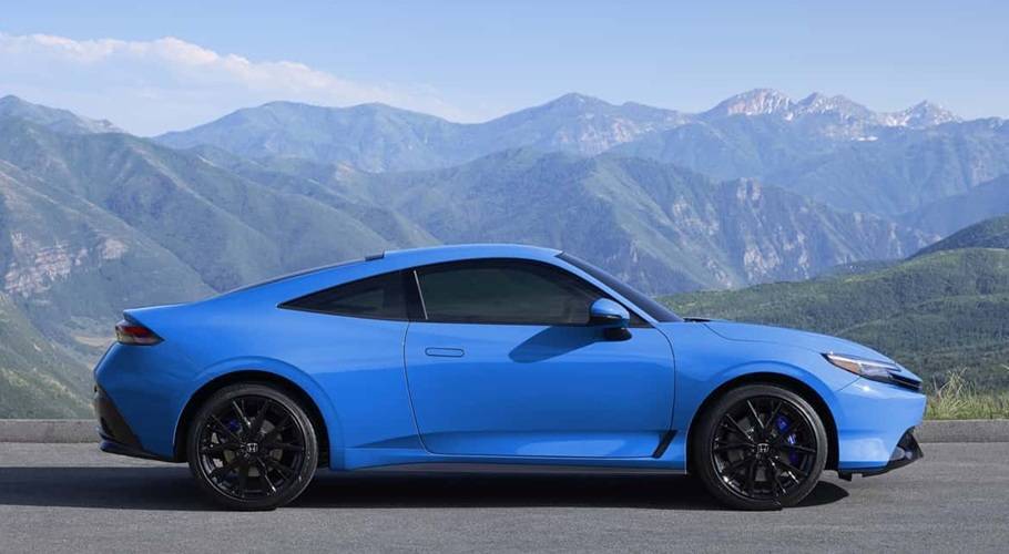 Honda Prelude 2025 blu elettrico vista laterale su strada panoramica, la nuova coupé ibrida sportiva da 200 CV presentata da Brandini