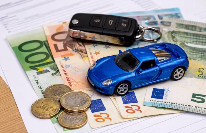 Chiavi, banconote in euro e modellino di auto rossa: simbolo delle offerte vantaggiose per l’acquisto di auto nuove con rate mensili sotto i 150€.